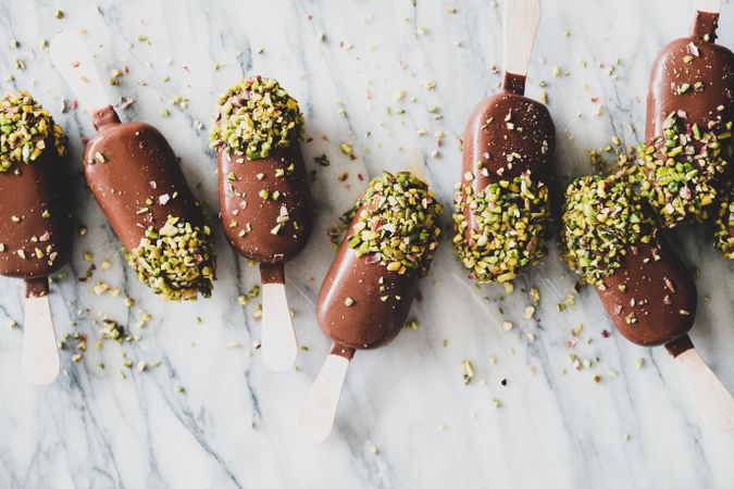 Ice cream chocolate pistachio popsicles, light background, top view