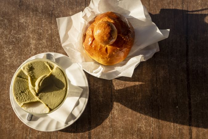 Top view of Sicilian granita with pistachio and almond flavors served with brioche in morning light
