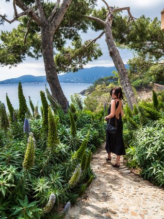 Woman in a chic dress elegantly poses near the pool at a luxurious villa