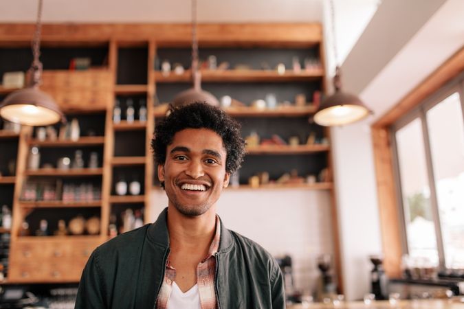 Portrait of happy young man standing in a cafe