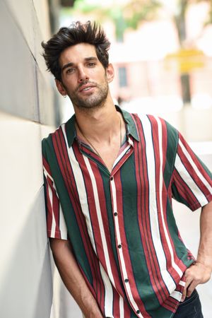 Portrait of man with dark hair posing outside