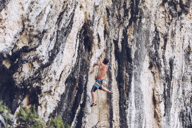 Anonymous man climbing rock