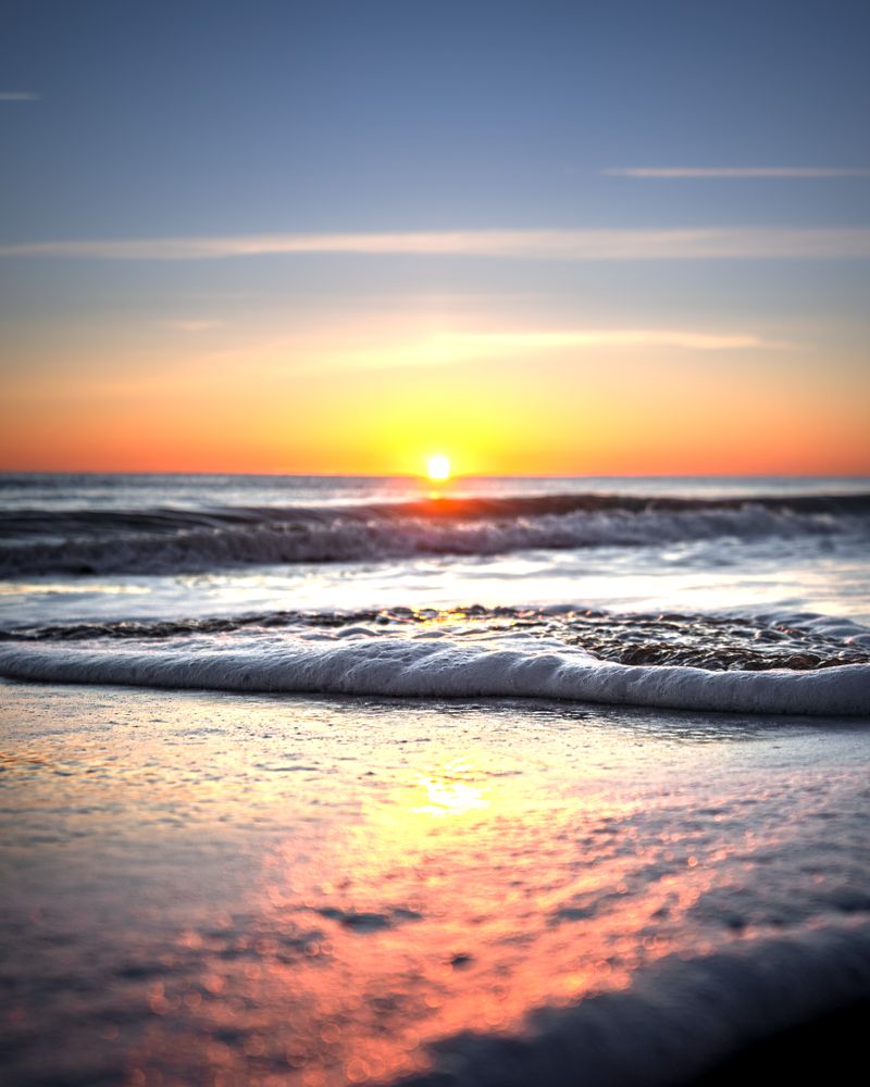 Sea waves crashing on shore in close-up during sunrise