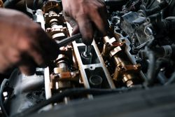 Close of mechanic’s hands in the hood of a vehicle