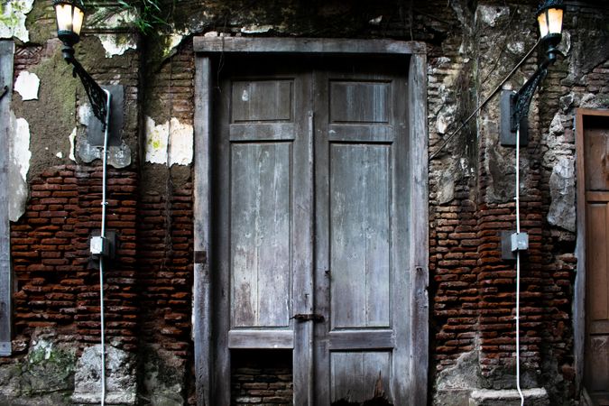 Big old broken wooden door on brick wall of historical building located in Kota Lama, Semarang City, Indonesia.