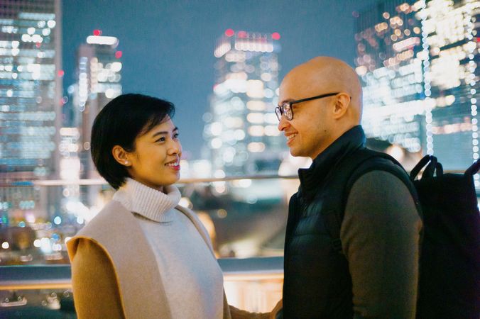 Man standing beside woman in the city at nighttime