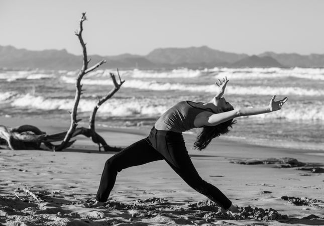 Young woman dancing and posing near water on shore