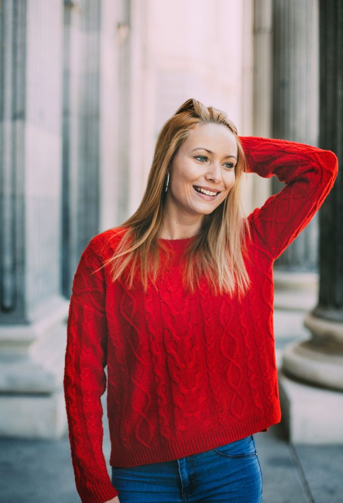 Stylish female standing near marble columns