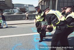 London, England, United Kingdom - April 19th, 2019: Police grabbing protestor spraying graffiti 4MGJr0