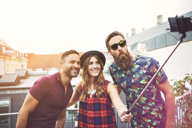 Happy friends smiling while taking a selfie outside