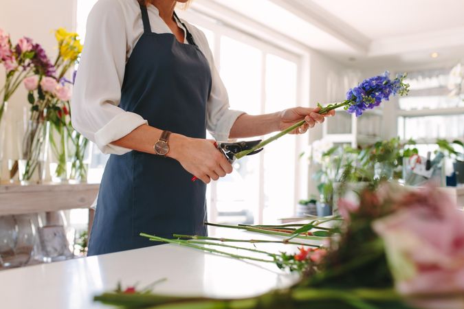 Female florist creating bouquet of flowers at shop