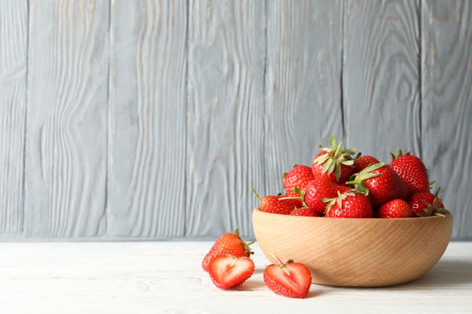 Bowl with tasty strawberry on wooden table. Summer berry