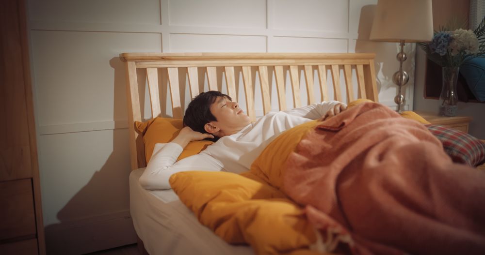 Korean Young Man Getting Awaken by the Sun Shining Through his Window.