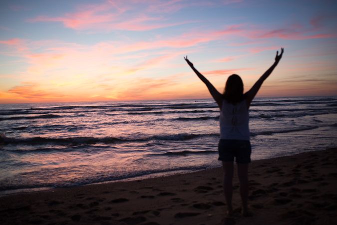Female tourist posing on seaside at sunset