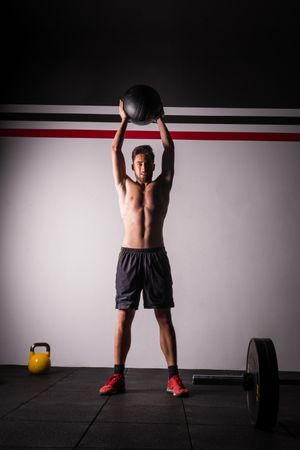 Man throwing ball on wall in gym