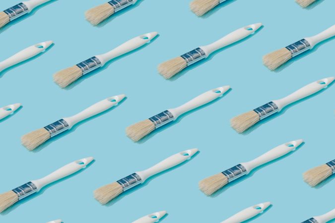 Pattern composition of light  paint brushes on pastel blue background