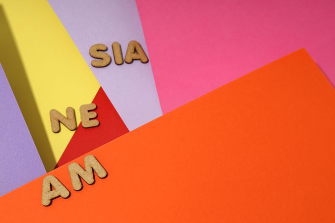 Scattered letters spelling “amnesia” on colorful paper background, copy space