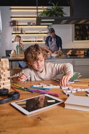 Little boy playing with domino in kitchen at home