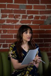 Transgender woman sitting and discussing notes in hand with a colleague