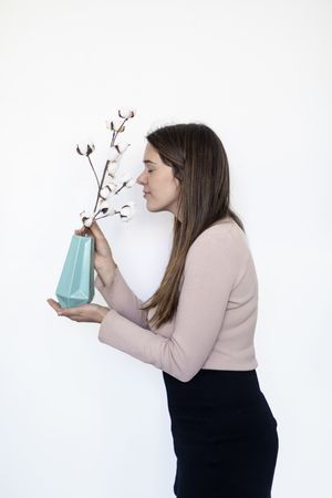 Portrait of a pretty woman smelling a plant