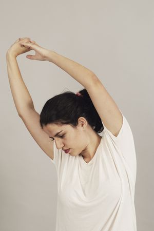 Concentrated young active female athlete exercising in studio