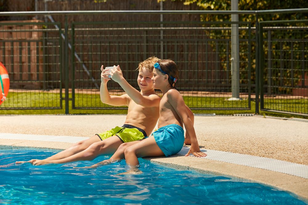 Boys on poolside taking selfie