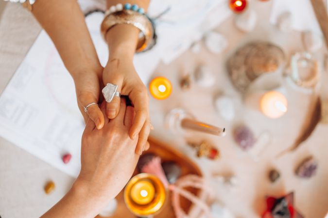 Cropped image of person comforting another person over candles and ornament