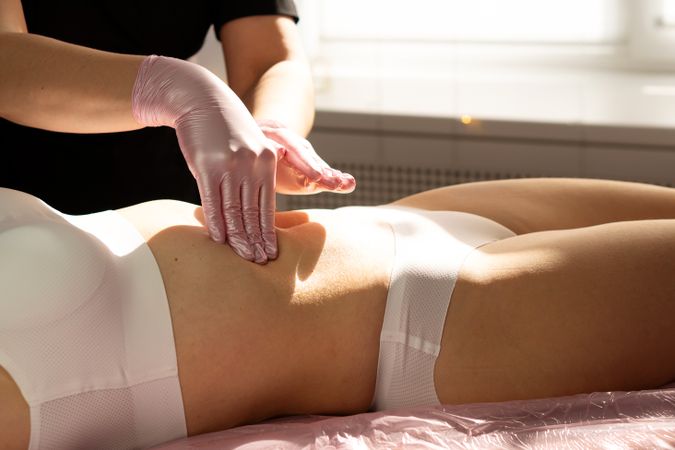 Hands massage abdomen gently in final step of honey therapy.