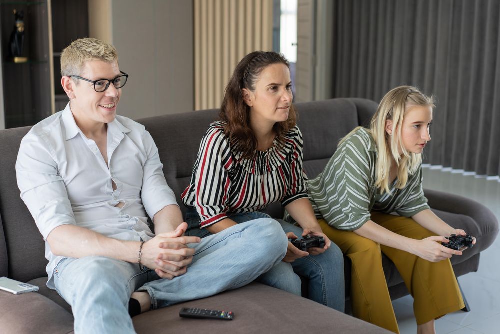 Mother and daughter playing video game together in the living room