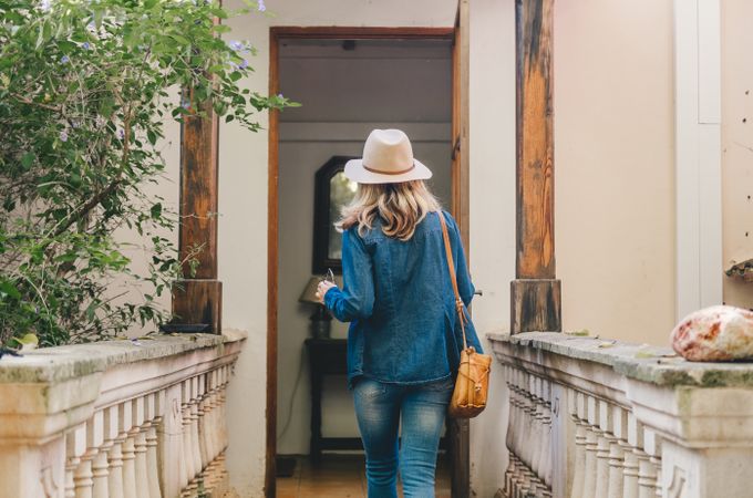 Woman standing by door of old house