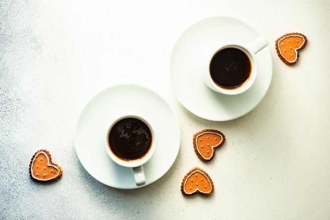 Top view of two coffees with scattered sugar cookies