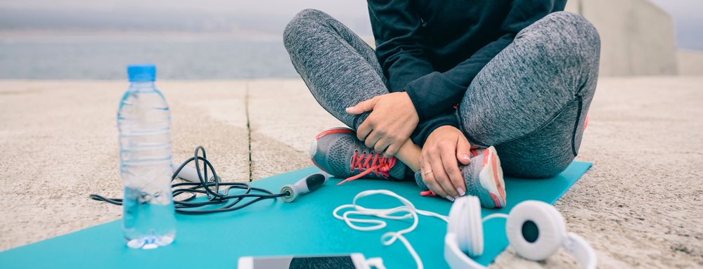 Low section of woman sitting with sport accessories