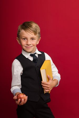 Cute guy hold yellow book and apple