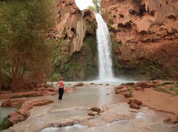 Woman standing below Havasu Falls in Arizona