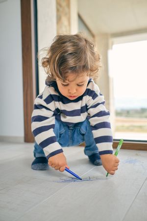 Concentrated toddler drawing on floor