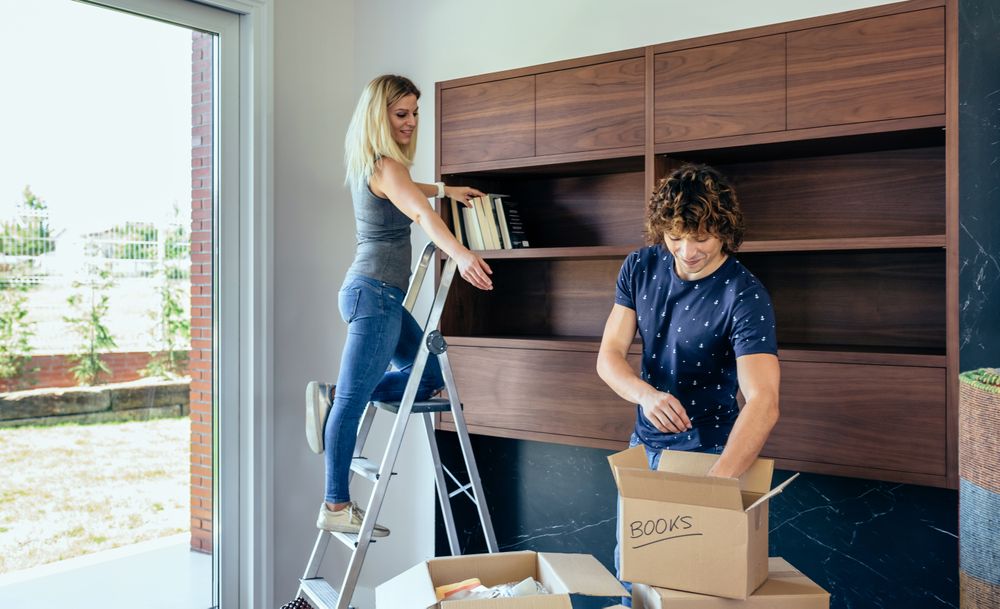 Couple unpacking boxes and placing books