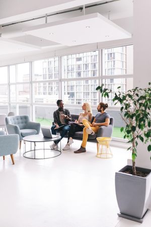 Coworkers having a discussion in a bright modern office