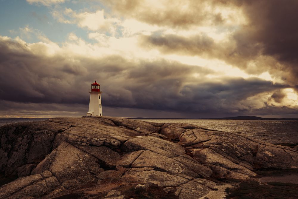 Lighthouse tower on rocks near ocean