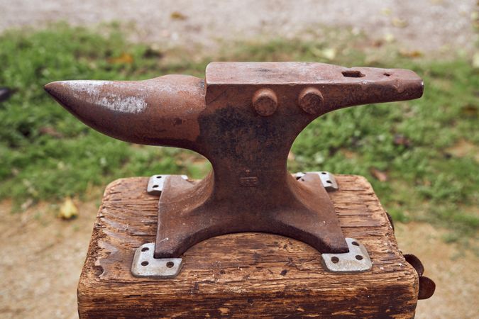 Blacksmith working on the anvil changing the horseshoe to a paw with tools