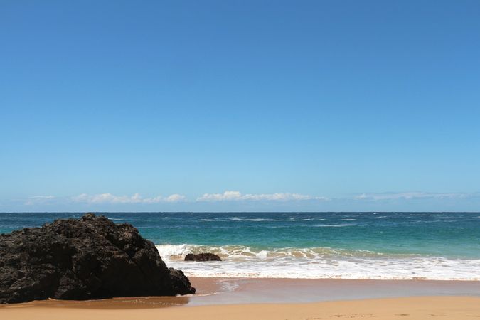 Relaxation and tranquility by the ocean with clear blue sky and gentle waves on a sunny day