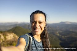 A young woman smiles at the sun from the top of a mountain near Pgasarri in the Basque Country 49mmay
