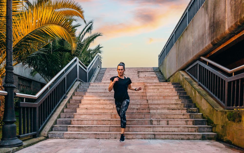 Female runner training on stairs at dusk