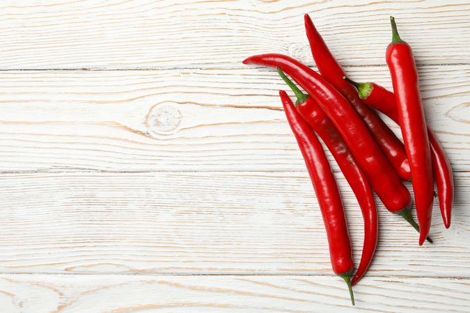Chilli peppers on wooden background, top view