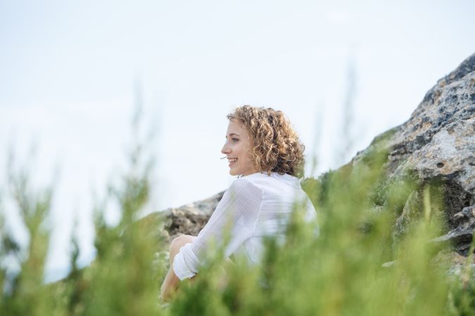 Young woman sitting between stones and branches