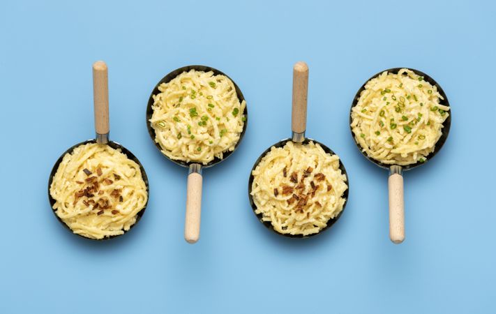 Spaetzle in iron pans on a blue table