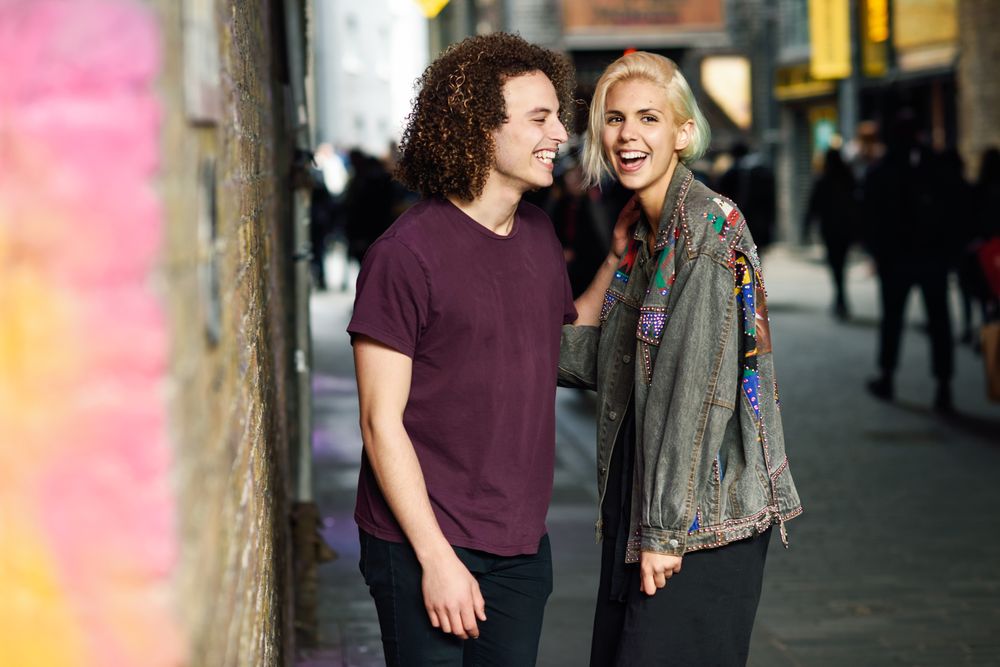Male and female laughing on British city street