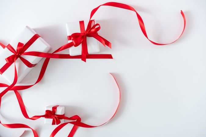 Gift boxes wrapped with red ribbons on light background
