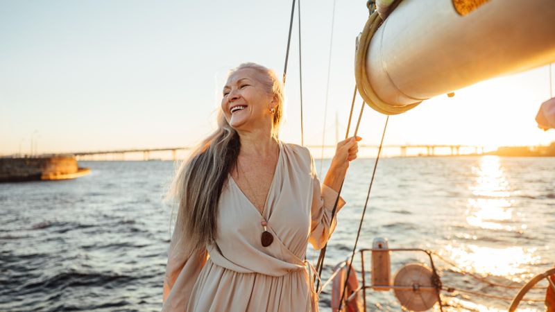 Beautiful woman smiling at sunset at the front of a yacht