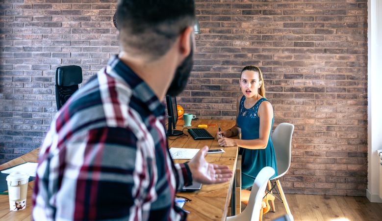 Woman shocked by what her coworker is telling
