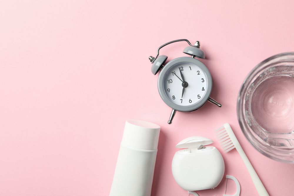 Tools for dental care on pink background, top view